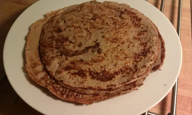 En hög med tunna pannkakor på en vit tallrik. Perfekt för en mysig frukost eller som frukost tips.