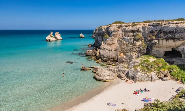 Spiaggia con scogli e mare cristallino, un angolo di paradiso in Puglia dove andare al mare.