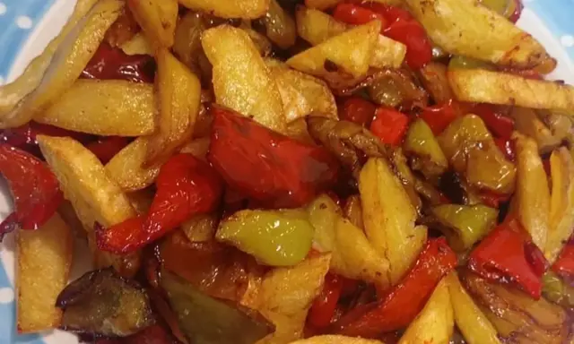 Patate fritte croccanti e peperoni colorati, un contorno saporito che ricorda la semplicità delle pipi e patate fatte in casa.