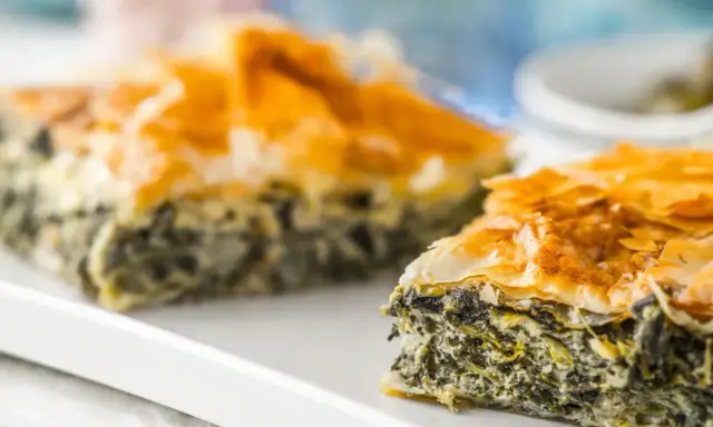 Chrupiąca spanakopita z warstwami ciasta filo i zielonym nadzieniem ze szpinaku i sera.