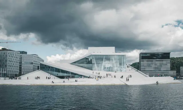 Nowoczesna architektura Opery w Oslo, gdzie prawo jante jest widoczne w kaskadowych, białych dachach schodzących do wody.