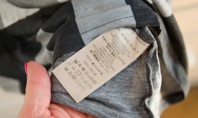 Metka z napisem Burberry, Made in Portugal. Sprawdź metkę, by dowiedzieć się, jak rozpoznać oryginał.