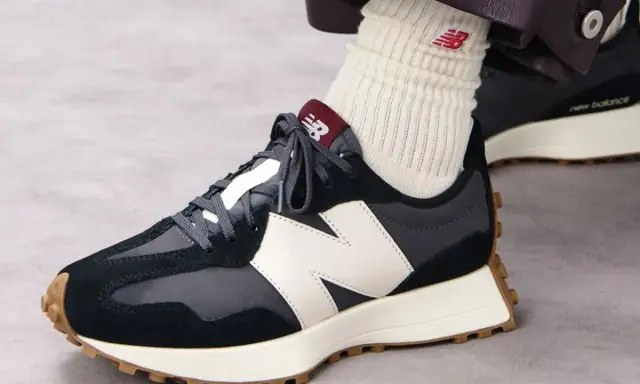Jak wiązać sznurówki w sneakersach New Balance? Zobacz, jak elegancko prezentują się te ciemne buty z białym logo.