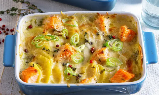 Herzhaftes Fischgericht mit Kartoffeln, überbacken mit Käse und garniert mit Frühlingszwiebeln und rosa Pfeffer.