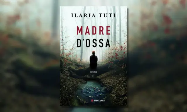 Copertina del romanzo "Madre d'ossa" di Ilaria Tuti. Una figura solitaria siede in un bosco nebbioso, vicino a un ruscello.
