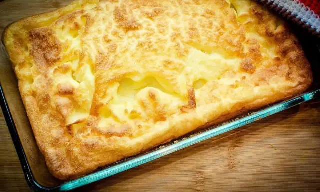 En gyllene, fluffig ugnspannkaka i en glasform, redo att serveras. Ett perfekt ugnspannkaka recept för en mysig middag.