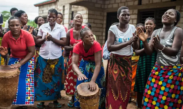 Des femmes africaines jouent du tambour et chantent, un parfait synonyme de sororité.