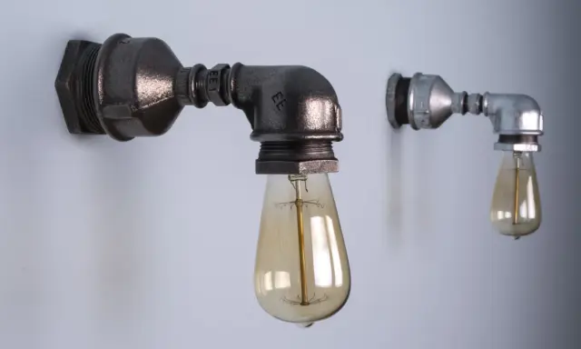 Dwie industrialne lampy z rurek, jedna większa, ciemniejsza, druga mniejsza, jaśniejsza, obie z żarówkami Edisona.