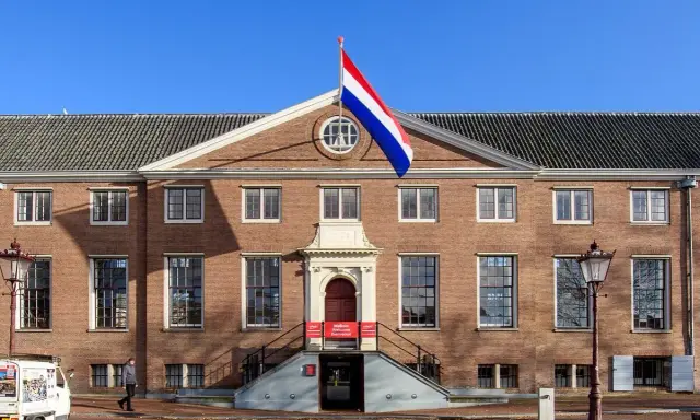 Det ståtliga konstmuseet i Amsterdam, med Nederländernas flagga vajande stolt.