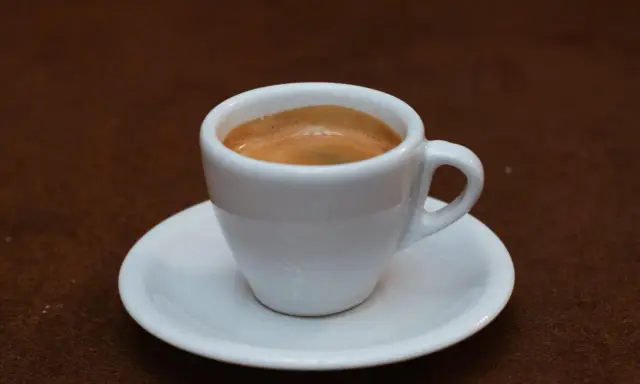 Eine Tasse mit cremigem Espresso Doppio auf einer Untertasse, bereit für den Genuss.