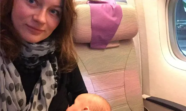 Kobieta karmi niemowlaka podczas lotu samolotem.