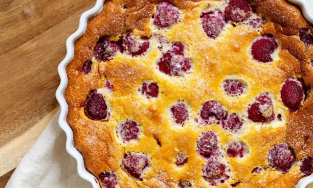 Un délicieux clafoutis framboise tout juste sorti du four, saupoudré de sucre glace. Parfait pour un goûter gourmand.