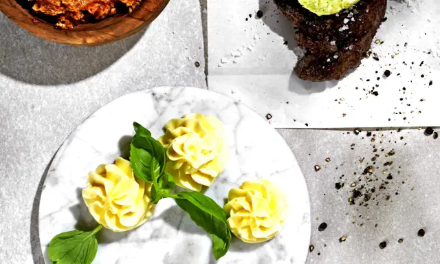 Ein Steak mit Kräuterbutter, dazu Kartoffelröschen und eine Schüssel mit einer roten Paste. Perfekt für ein knoblauchbutter rezept.