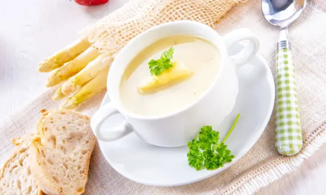 Cremige Spargelsuppe mit frischem Spargel, Brot und Petersilie. Ein köstliches Spargelsuppe Rezept für Genießer.