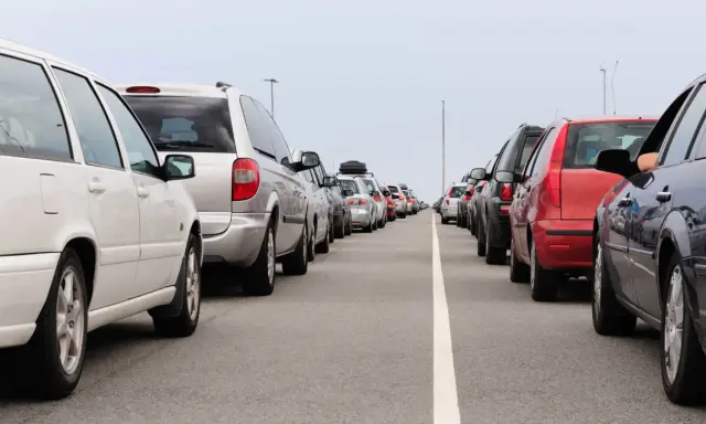 Fila de coches en carretera. Evita la multa por adelantar en línea continua.