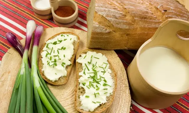 Chleb z twarogiem i szczypiorkiem, obok mleko i cebulka. Idealne składniki na zaprawę do wyrobu bryndzy.