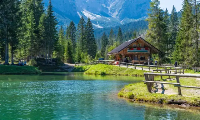 Rifugio alpino in Italia, con lago cristallino e montagne sullo sfondo. Perfetto per una vacanza in montagna Italia.