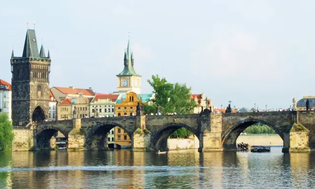 Most Karola w Pradze, z wieżą i zabytkowymi budynkami. To piękne informacje o Czechach.
