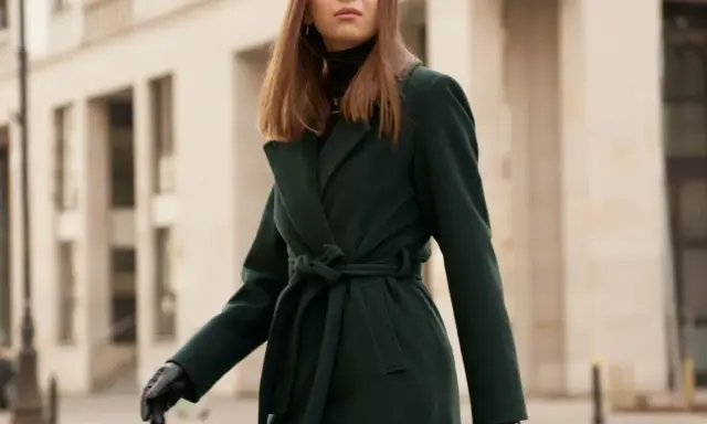 Elegancka kobieta w ciemnozielonym płaszczu z alpaki, z paskiem zawiązanym w talii. Dowiedz się, jak prać płaszcz z alpaki, by zachował swój urok.