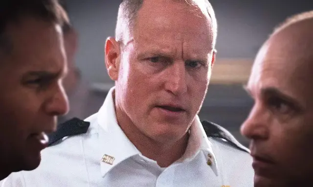 Woody Harrelson i en vit skjorta, omgiven av andra män. En scen från filmer och tv-program med Woody Harrelson.