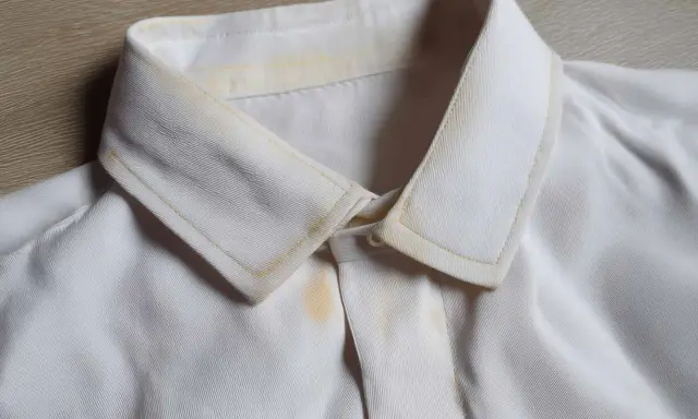 Vergilbter Kragen eines weißen Hemdes, bereit zum hemd bleichen. Gelbe Flecken sind sichtbar.
