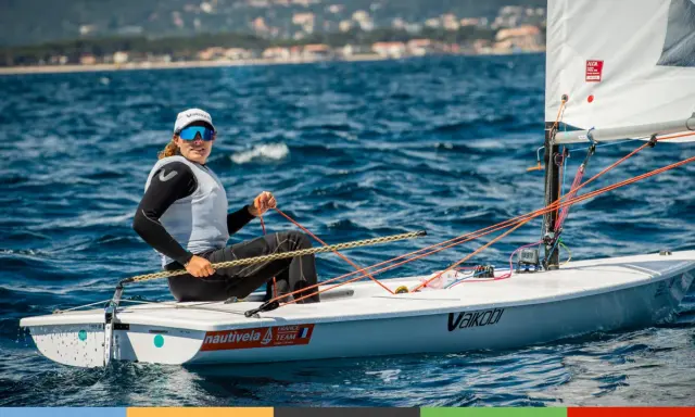 Louise Cervera, navigatrice française, manœuvre son dériveur ILCA sur une mer bleue. Elle porte une casquette et des lunettes de soleil.