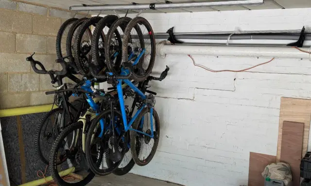 Système de rangement astucieux pour vélos dans un garage, plusieurs vélos suspendus au plafond pour optimiser l'espace.