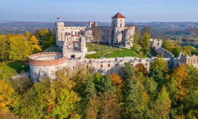 Ruiny zamku na wzgórzu, otoczone jesiennym lasem. Piękny krajobraz Jury Krakowsko-Częstochowskiej.