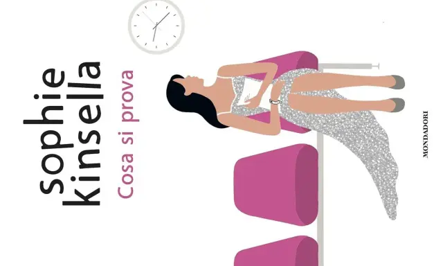 Copertina di "Cosa si prova", un libro di Sophie Kinsella. Una donna in abito scintillante è sdraiata su una poltrona rosa, con un orologio in alto.