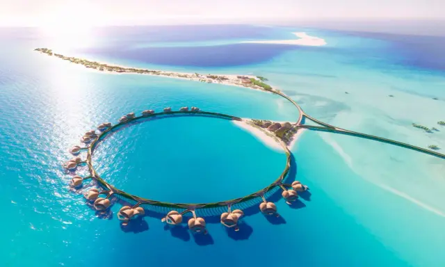 Resort circolare su palafitte nel Mar Rosso Arabia Saudita, con isole sabbiose e acque turchesi.