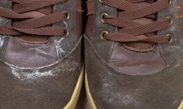 Brązowe zamszowe buty z białym nalotem, pokazujące jak usunąć wosk z butów zamszowych.