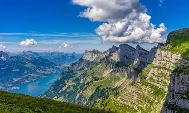 Widok na góry Alpy z jeziorem i chmurami.