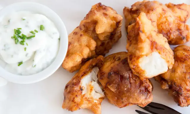 Knusprig frittierte Fischstücke, perfekt für ein Kibbeling Rezept, mit einem cremigen Dip mit Schnittlauch.
