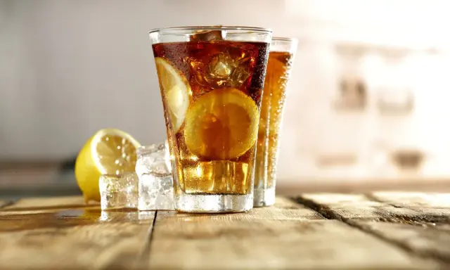 Dwa orzeźwiające long island iced tea z plasterkami cytryny i lodem, gotowe do degustacji.