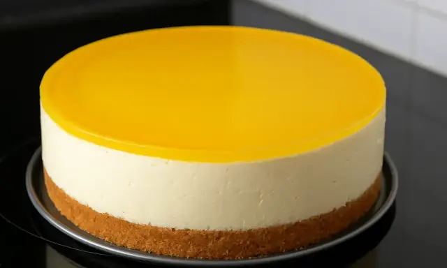 Un délicieux dessert au citron sans cuisson, avec une base biscuitée, une crème onctueuse et un glaçage jaune vif.