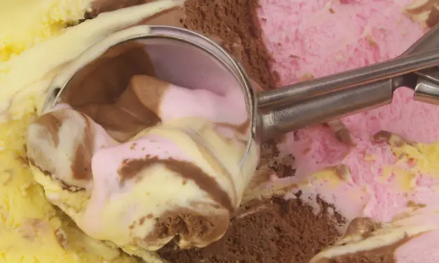 Łyżka do lodów nabiera porcję pysznego, kolorowego gelato. Czy to czekoladowe, truskawkowe, czy waniliowe?