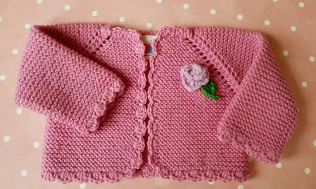 Chaqueta a crochet para bebé de 3 a 6 meses, rosa con flor lila y hoja verde. Ideal para abrigar a tu pequeño con estilo.