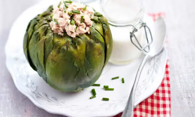 Artichaut farci de thon, garni de ciboulette. Une idée de recette artichaut simple et savoureuse, accompagnée d'une sauce crémeuse.