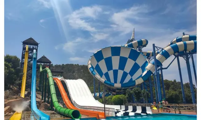 Toboganes acuáticos de colores vibrantes y una piscina azul cristalina, ideal para saber qué hacer en Benidorm con niños y disfrutar de un día refrescante.