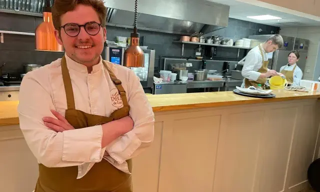 Le chef souriant du restaurant Le Mans, avec son équipe en cuisine.