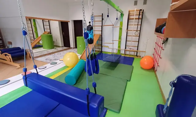 Sala do terapii SI z huśtawkami, materacami i piłkami. Sprzęt może pomóc w rozpoznaniu pierwszych objawów zaburzenia integracji sensorycznej.