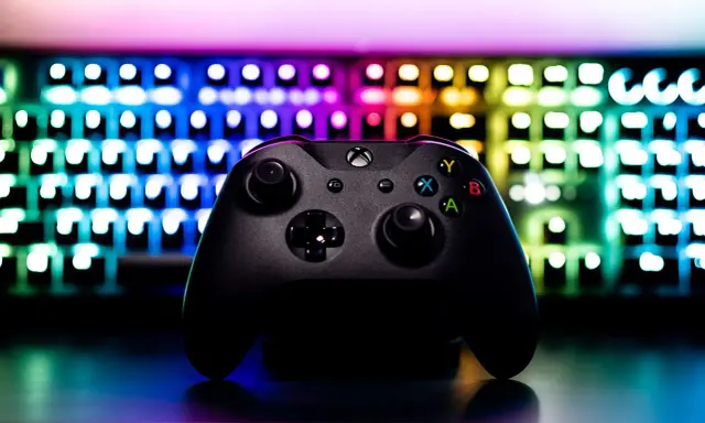 Czarny kontroler Xbox na tle podświetlanej klawiatury RGB. Idealny sprzęt do **grania na długie godziny**.