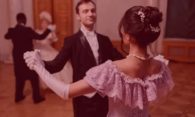 Elegancka para tańczy powolny walc na balu. Ona w pastelowej sukni, on w fraku.