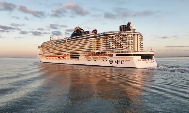 La MSC Seascape, imponente nella sua lunghezza, solca le acque calme al tramonto, riflettendosi sul mare.