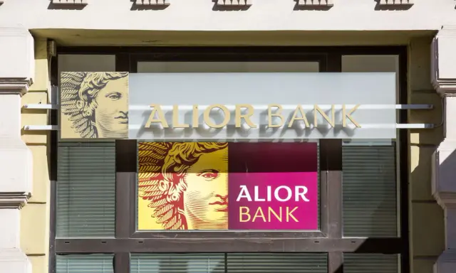 Alior Bank oferuje innowacyjne rozwiązania, w tym dostęp do kryptowalut. Na fasadzie banku widnieje logo z wizerunkiem głowy.