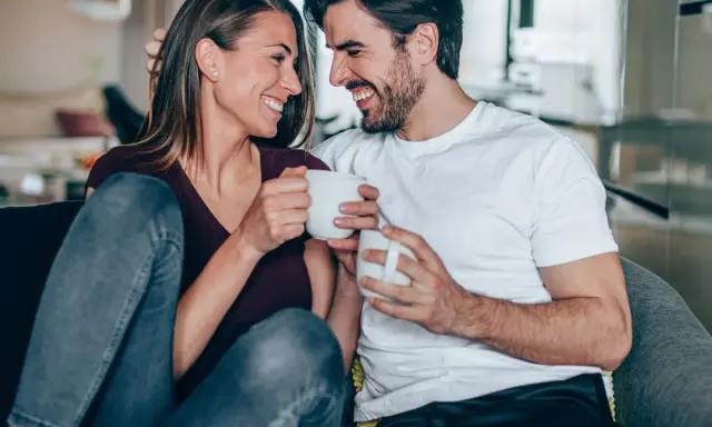 Para jak **byk** i **ryby** w akwarium, śmieją się, trzymając kubki.