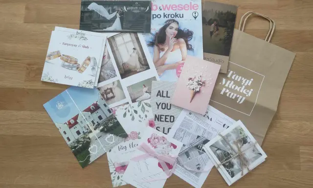 Materiały z targów ślubnych: magazyny, zaproszenia, zdjęcia i torba z napisem "Targi Młodej Pary".