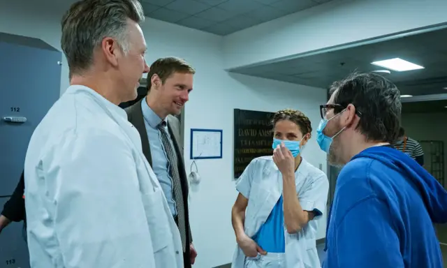 Tuva Novotny och Alexander Skarsgård i samtal med sjukhuspersonal.