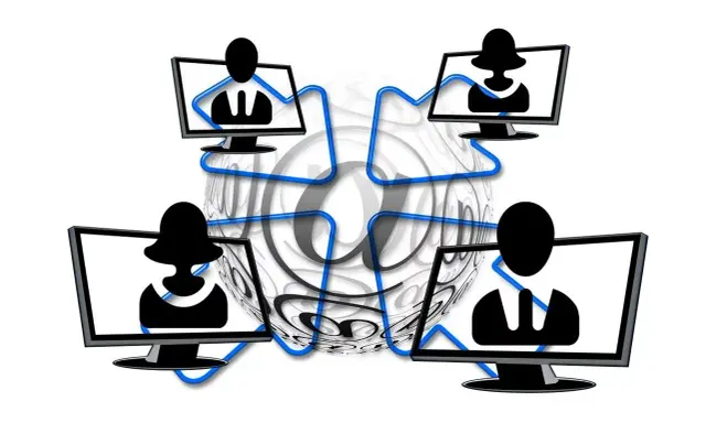 Vier Monitore mit Silhouetten von Personen, verbunden durch blaue Linien, umgeben von einem großen @-Symbol. Dies symbolisiert die Vernetzung und die Bedeutung von Online-Kommunikation, aber auch die Gefahr von "hijacking" – der Übernahme von Accounts.