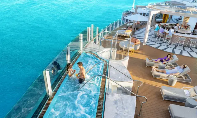 Coppia in jacuzzi su nave da crociera Caraibi, con bar e lettini prendisole. Un sogno di volo e crociera Caraibi.
